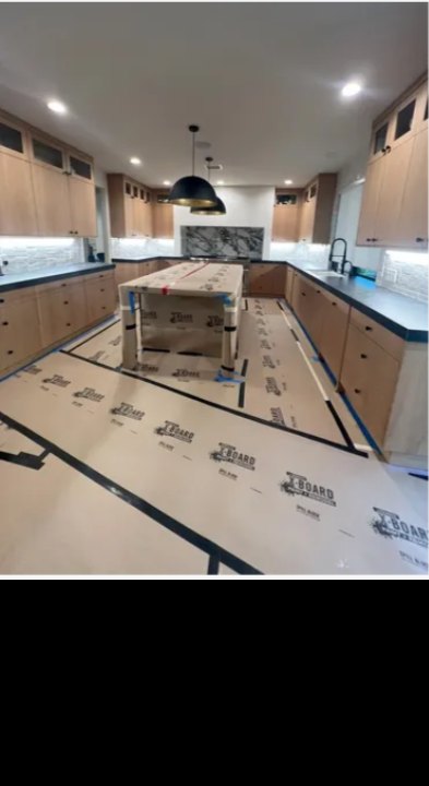Custom kitchen remodeling project with wood cabinets and protected finish flooring