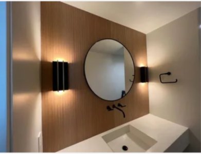 Modern powder room remodel with wood accent wall and round mirror